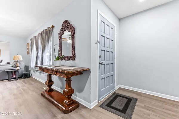 a room with gym equipment and wooden floor