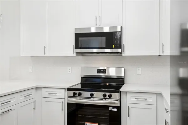 a kitchen with stainless steel appliances a stove a microwave and cabinets