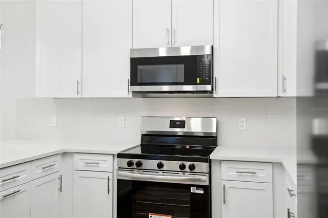 a kitchen with stainless steel appliances a stove a microwave and cabinets