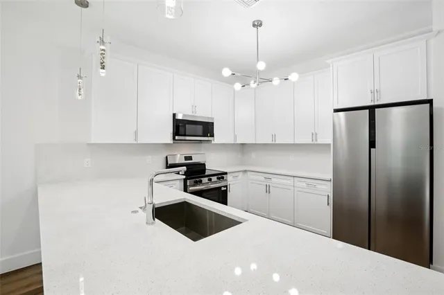 a kitchen with stainless steel appliances a refrigerator sink and microwave