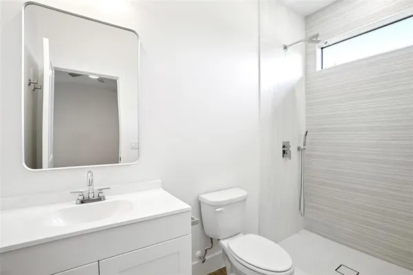 a bathroom with a toilet a sink and mirror