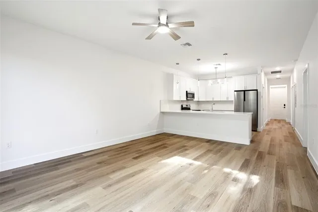 a view of a kitchen with wooden floor and a kitchen space