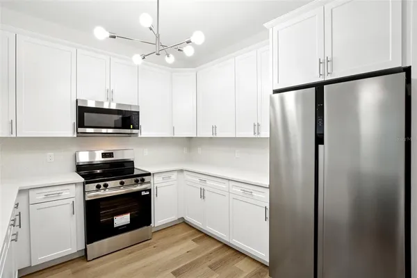 a kitchen with white cabinets and stainless steel appliances