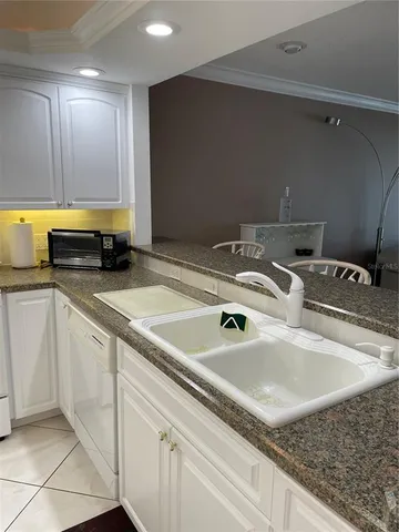 a kitchen with kitchen island a sink a stove and cabinets