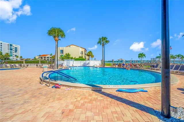 a view of a swimming pool with lawn chairs