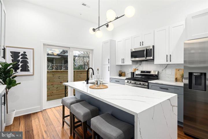 2322 Mutter Street Philadelphia, PA 19133 - Photo 18 of 34 a kitchen with a stove a sink a dining table and chairs