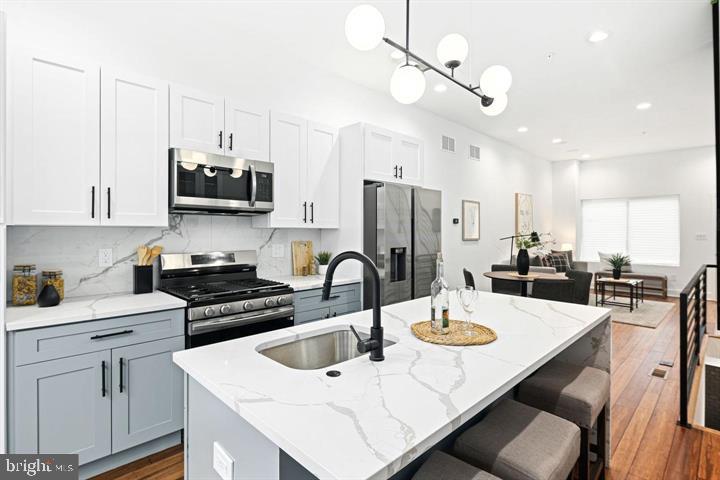 2322 Mutter Street Philadelphia, PA 19133 - Photo 20 of 34 a kitchen with stainless steel appliances a dining table a stove a refrigerator a center island a dining table and chairs