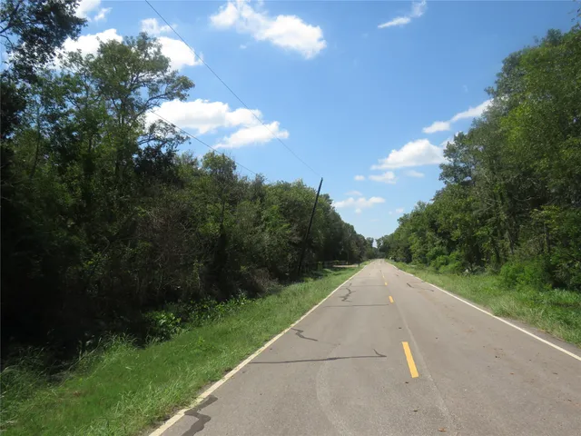 a view of a street both side of grassy field with shrub
