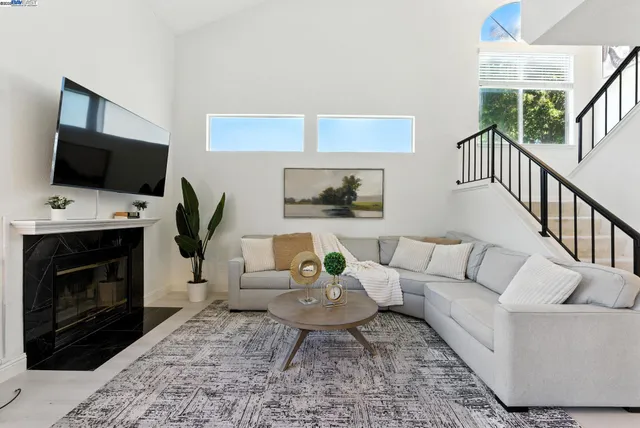 a living room with furniture a flat screen tv and a fireplace