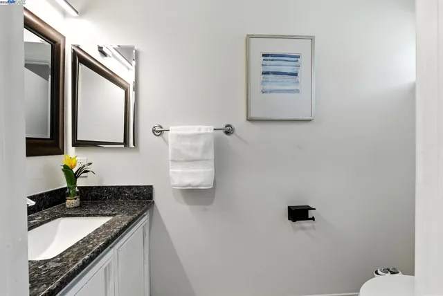a bathroom with a granite countertop sink and a mirror