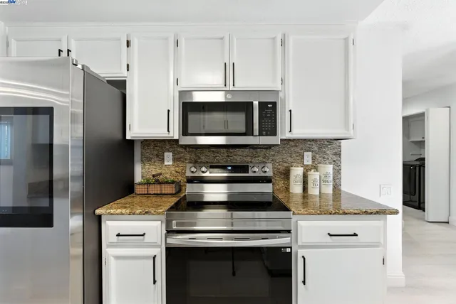 a kitchen with stainless steel appliances a stove a microwave and cabinets