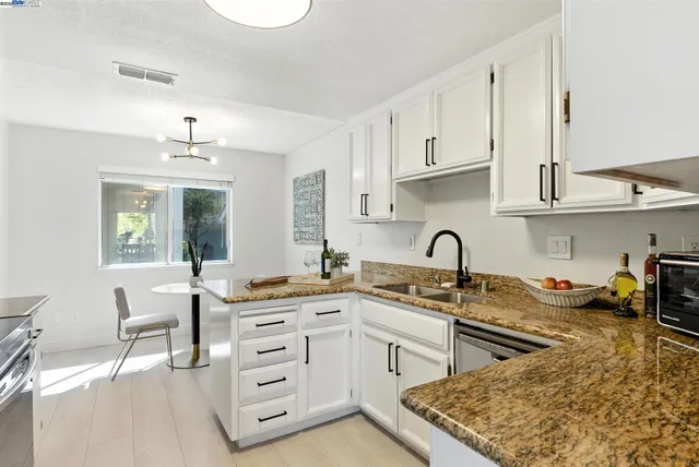a kitchen with stainless steel appliances granite countertop a sink stove and cabinets
