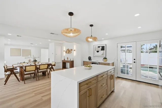 a kitchen with stainless steel appliances kitchen island granite countertop a stove and a wooden floors
