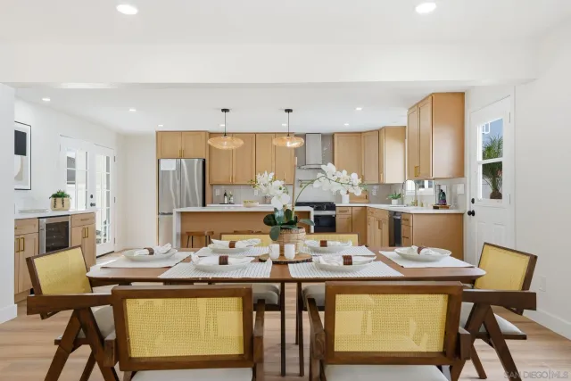 a dining room with stainless steel appliances kitchen island granite countertop a dining table and chairs