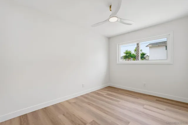 an empty room with a window and wooden floor