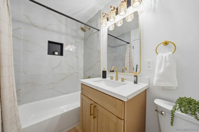 a bathroom with a sink vanity mirror and toilet