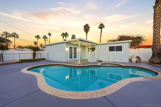 a view of a house with swimming pool and sitting area