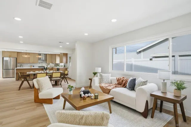 a living room with furniture kitchen view and a table
