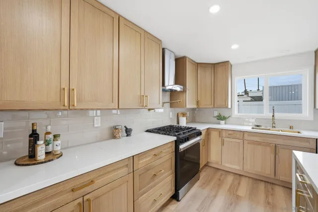 a kitchen with stainless steel appliances granite countertop a sink a stove and cabinets