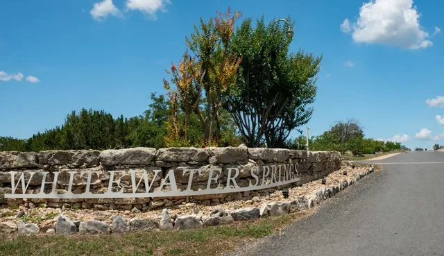 a view of swimming pool with outdoor seating and trees in the background