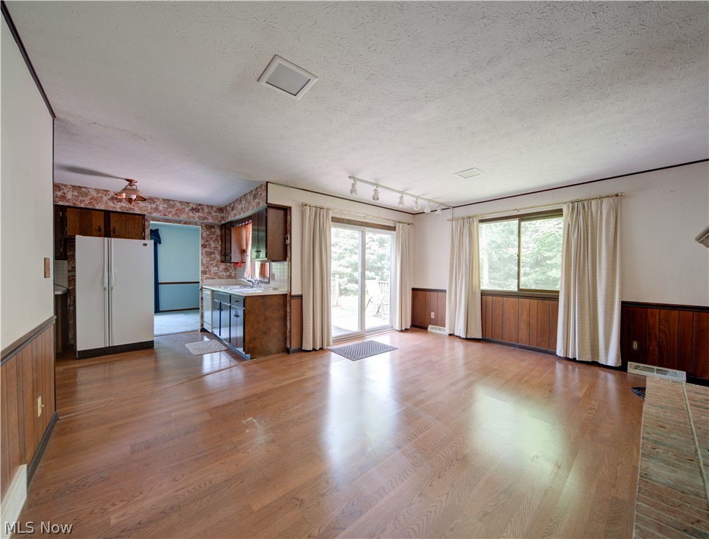 11430 Ferry Road Chesterland, OH 44026 - Photo 11 of 38 Unfurnished living room with wood-type flooring, a textured ceiling, and rail lighting