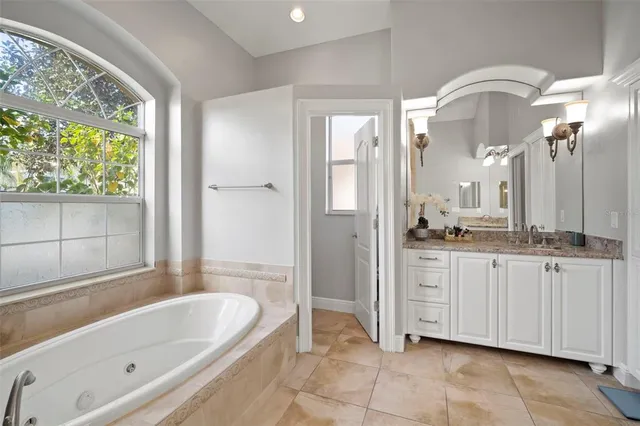 a bathroom with a tub sink and mirror