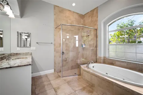 a bathroom with a granite countertop tub shower and sink