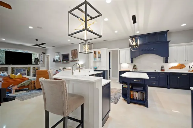 a living room with furniture a flat screen tv and kitchen view
