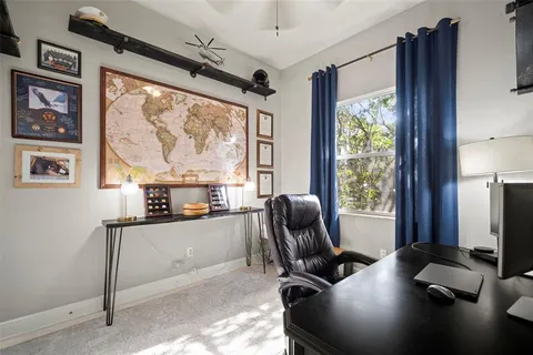 a view of a workspace with furniture and a window