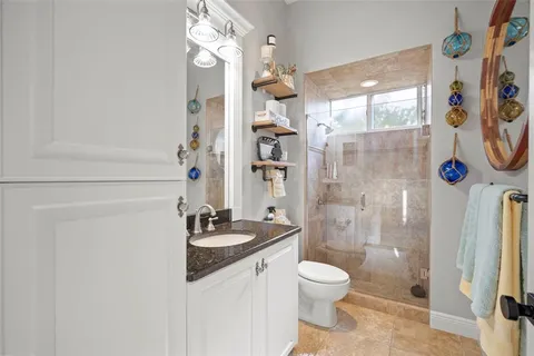 a bathroom with a granite countertop sink toilet and shower