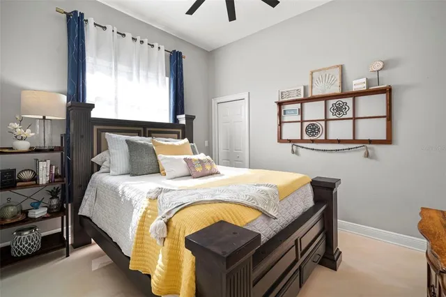 a bedroom with a bed a window and painting on the wall