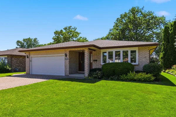 a view of a house with a yard and pathway