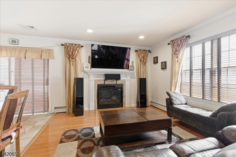 26 Eldora Road Parsippany, NJ 07054 - Photo 11 of 47 a living room with furniture a flat screen tv and a fireplace