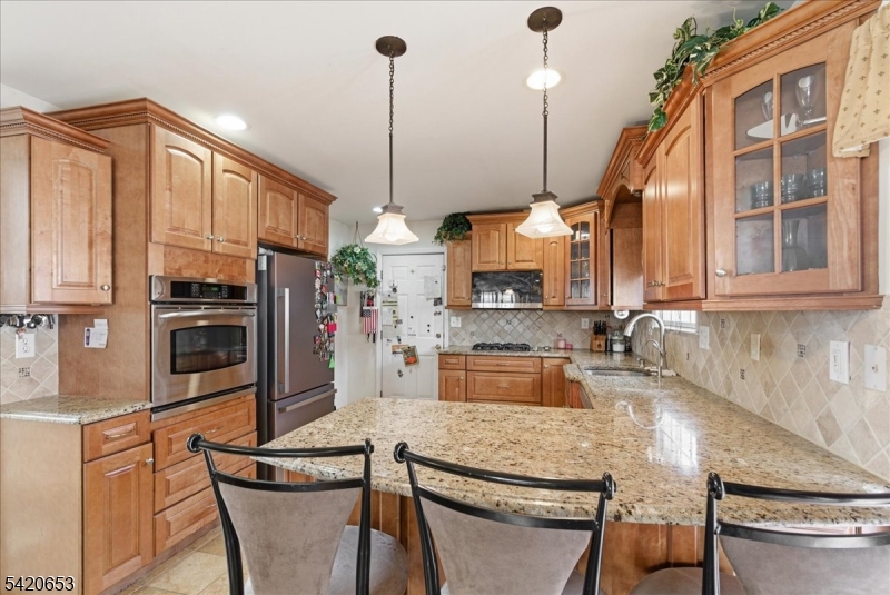 26 Eldora Road Parsippany, NJ 07054 - Photo 17 of 47 a kitchen with stainless steel appliances granite countertop a sink a stove and a wooden cabinets
