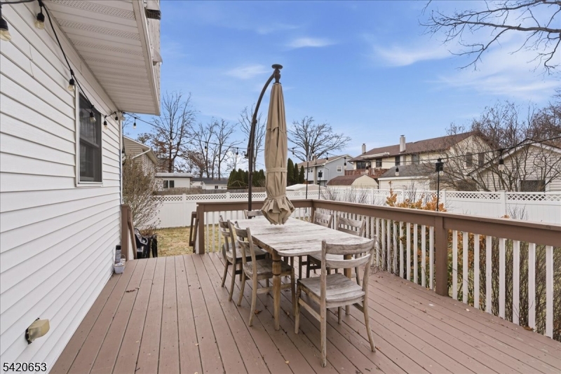 26 Eldora Road Parsippany, NJ 07054 - Photo 37 of 47 a view of a roof deck with table and chairs a barbeque with wooden floor and fence