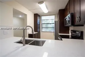 a view of a kitchen with a sink and a large window