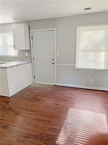a view of a kitchen with wooden floor and a sink