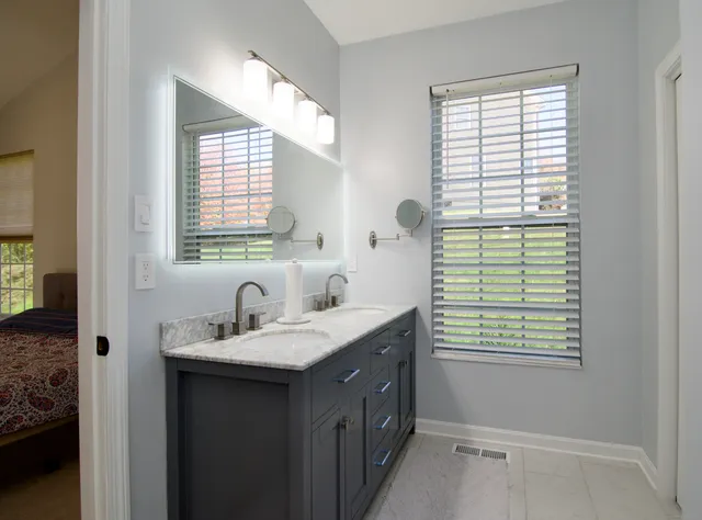 a bathroom with a sink window and a mirror