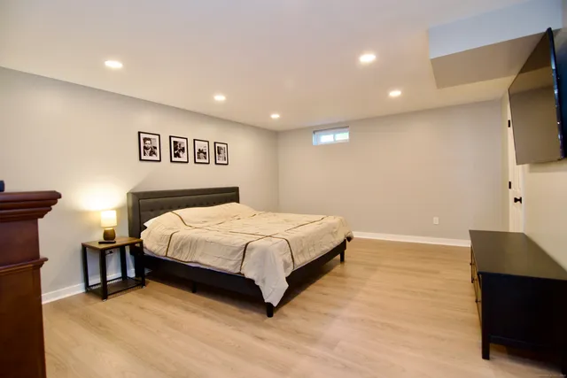 a spacious bedroom with a bed and a flat screen tv