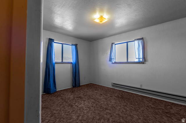 1208 East Tidwell Road Loa, UT 84747 - Photo 26 of 40 Carpeted empty room with baseboard heating and a textured ceiling