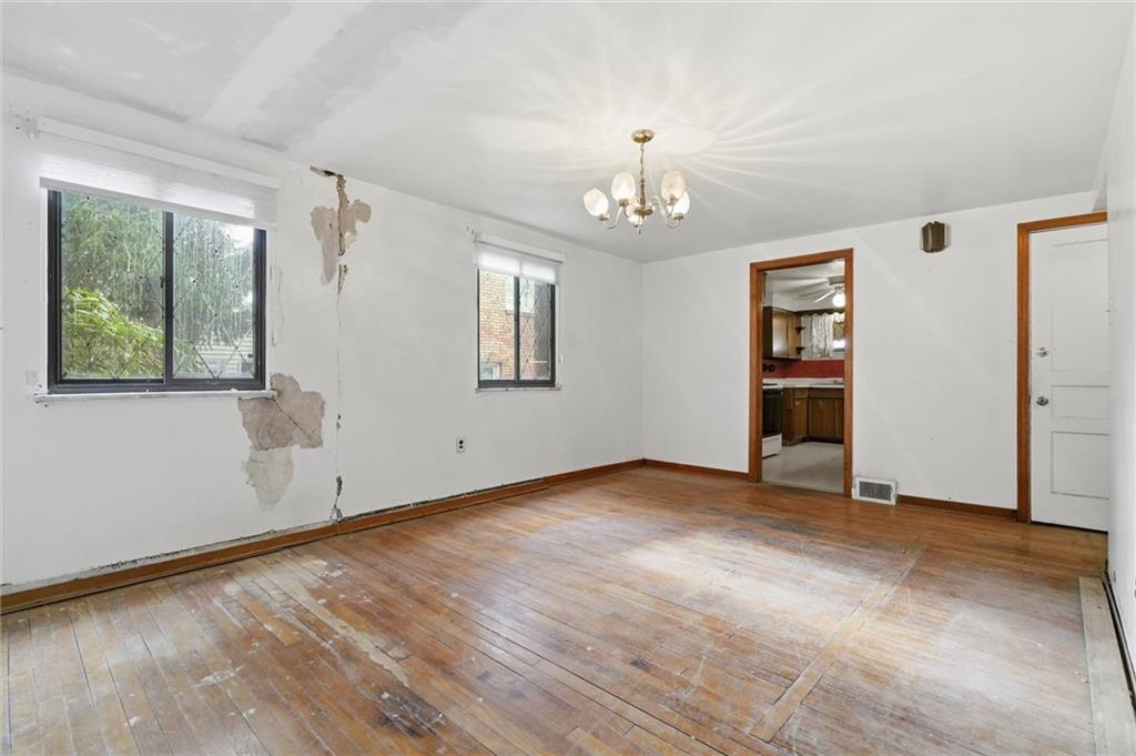 138 Enger Avenue Pittsburgh, PA 15214 - Photo 14 of 50 an empty room with wooden floor chandelier and windows
