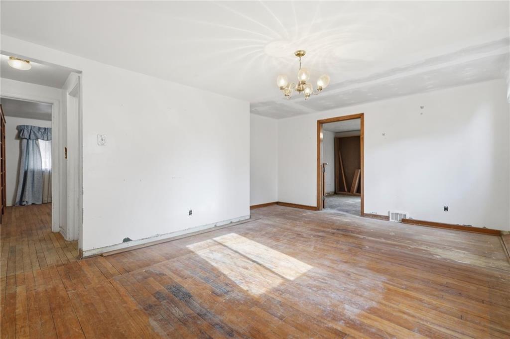 138 Enger Avenue Pittsburgh, PA 15214 - Photo 15 of 50 an empty room with wooden floor and chandelier
