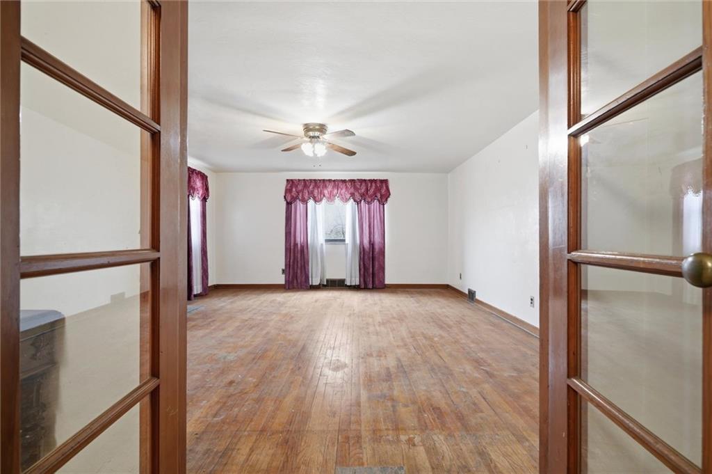 138 Enger Avenue Pittsburgh, PA 15214 - Photo 10 of 50 an empty room with wooden floor fan and windows