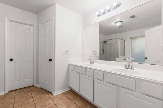 a bathroom with a double vanity sink mirror and