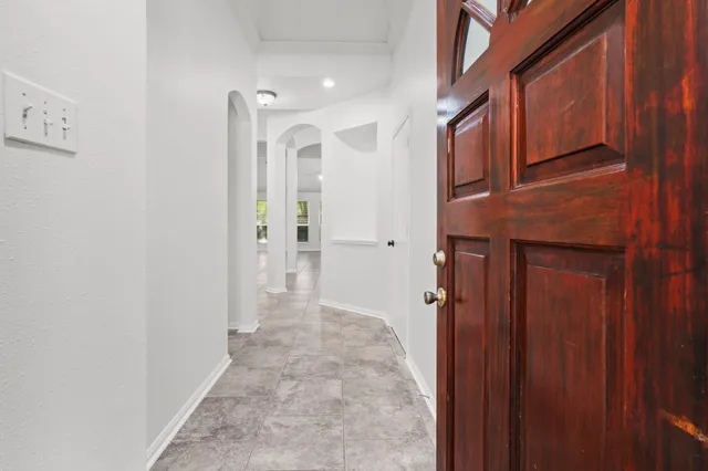 a view of a hallway with wooden cabinets