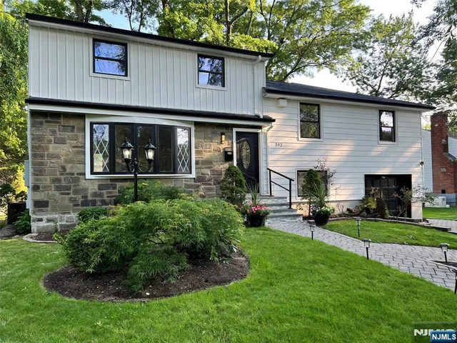 a front view of a house with a yard and potted plants