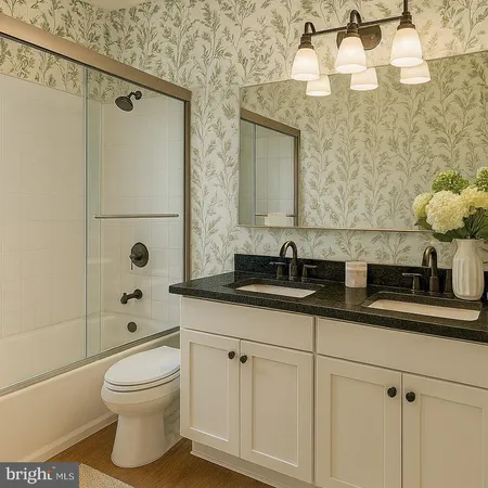 a bathroom with a granite countertop sink a toilet and shower