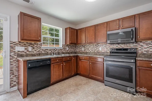 a kitchen with granite countertop cabinets stainless steel appliances and a sink