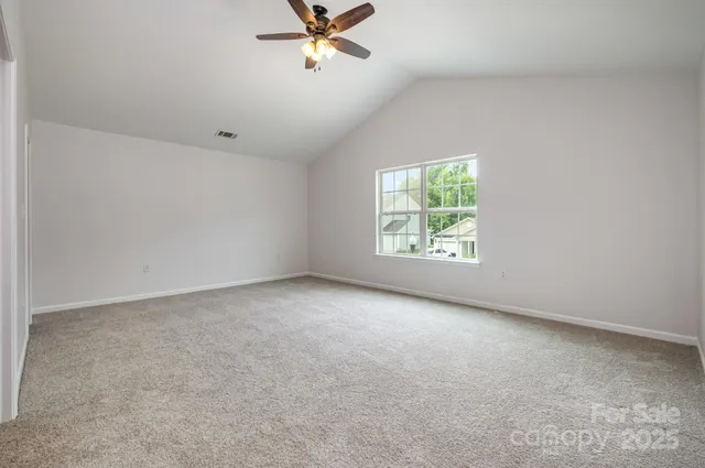 an empty room with windows and fan view