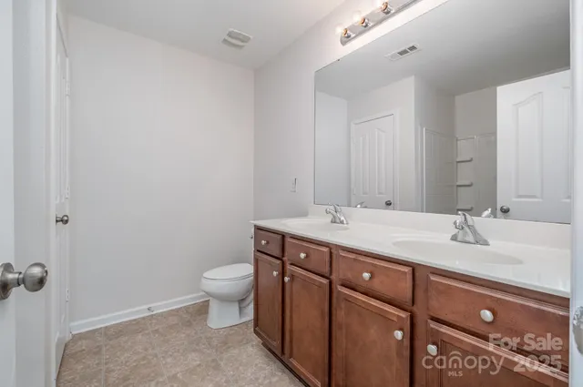 a bathroom with a sink and mirror with toilet